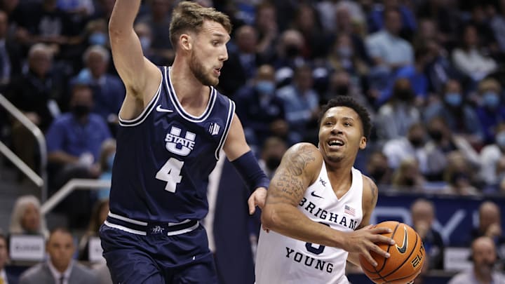 Dec 8, 2021; Provo, Utah, USA;  Brigham Young Cougars guard Te'Jon Lucas (3) drives against Utah State Aggies forward Brandon Horvath (4) in the second half at Marriott Center. Mandatory Credit: Jeffrey Swinger-Imagn Images