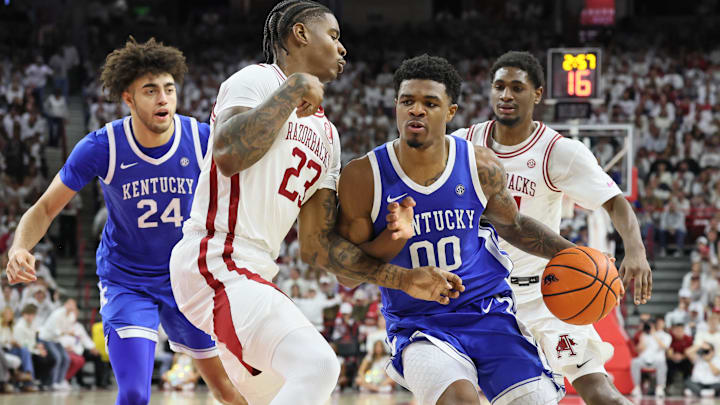 Jan 31, 2026; Fayetteville, Arkansas, USA; Kentucky Wildcats guard Otega Oweh (00) drives against Arkansas Razorbacks forward Nick Pringle (23) during the first half at Bud Walton Arena. Mandatory Credit: Nelson Chenault-Imagn Images