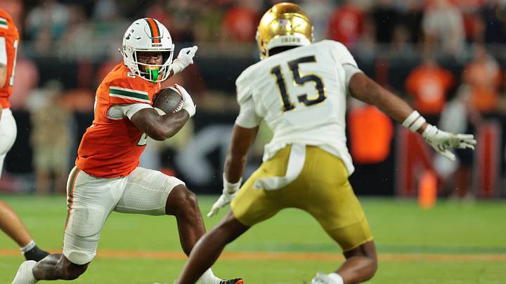 Aug 31, 2025; Miami Gardens, Florida, USA; Miami Hurricanes running back Jordan Lyle (2) rushes the ball against Notre Dame Fighting Irish cornerback Leonard Moore (15) during the second quarter at Hard Rock Stadium. Mandatory Credit: Sam Navarro-Imagn Images