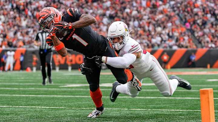 Cincinnati Bengals wide receiver Ja'Marr Chase (1) breaks a tackle from Arizona Cardinals linebacker Cody Simon (50) as he dives into the end zone for a touchdown in the first quarter of the NFL Week 17 game between the Cincinnati Bengals and the Arizona Cardinals at Paycor Stadium in Downtown Cincinnati on Sunday, Dec. 28, 2025. The Bengals led 23-7 at halftime.