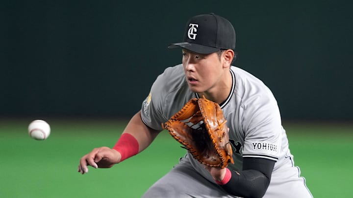 Mar 15, 2025; Bunkyo, Tokyo, Japan; Yomiuri Giants first baseman Kazuma Okamoto (25) fields a ground ball against the Los Angeles Dodgers during the fifth inning at Tokyo Dome. Mandatory Credit: Darren Yamashita-Imagn Images