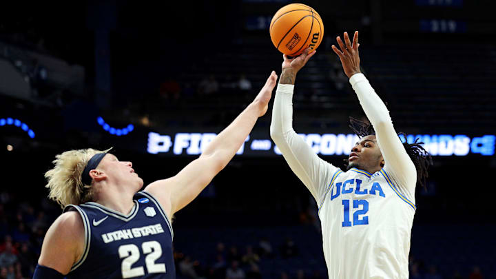 Mar 20, 2025; Lexington, KY, USA;  UCLA Bruins guard Sebastian Mack (12) shoots the ball against Utah State Aggies forward Karson Templin (22) during the second half in the first round of the NCAA Tournament at Rupp Arena. Mandatory Credit: Jordan Prather-Imagn Images