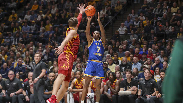 Jan 18, 2025; Morgantown, West Virginia, USA; West Virginia Mountaineers guard Javon Small (7) shoots a three-point shot over Iowa State Cyclones forward Brandton Chatfield (33) during the first half at WVU Coliseum. Mandatory Credit: Ben Queen-Imagn Images