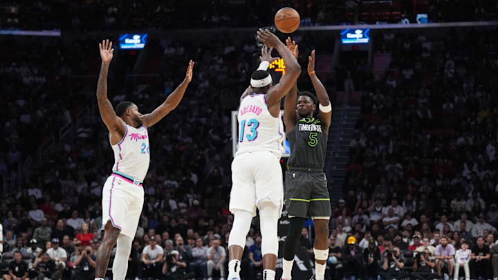 Mar 7, 2025; Miami, Florida, USA;  Minnesota Timberwolves guard Anthony Edwards (5) shoots over Miami Heat center Bam Adebayo (13) as forward Haywood Highsmith (24) closes in during the second half at Kaseya Center. Mandatory Credit: Jim Rassol-Imagn Images