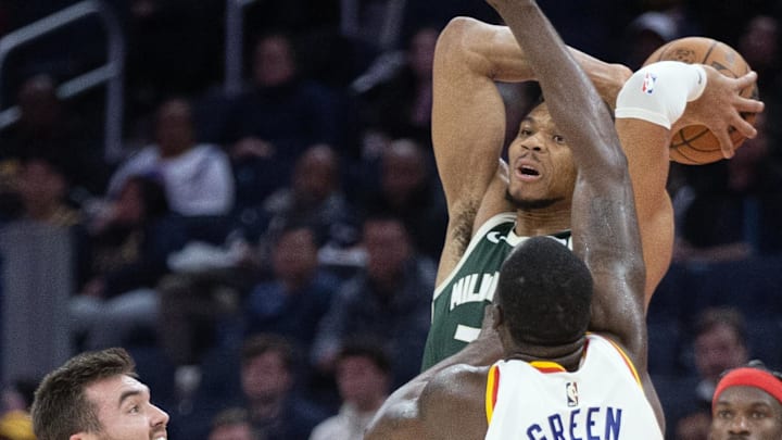 Mar 18, 2025; San Francisco, California, USA; Milwaukee Bucks forward Giannis Antetokounmpo (34) leaves his feet to pass over Golden State Warriors defenders Pat Spencer (61) and Draymond Green (23) during the second quarter at Chase Center. Mandatory Credit: D. Ross Cameron-Imagn Images
