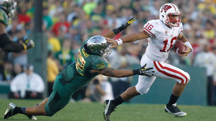Wisconsin Badgers QB Russell Wilson avoids the tackle of Oregon Ducks Dewitt Stuckey during the first half of the Rose Bowl in Pasadena, Calif. on January 2, 2012.