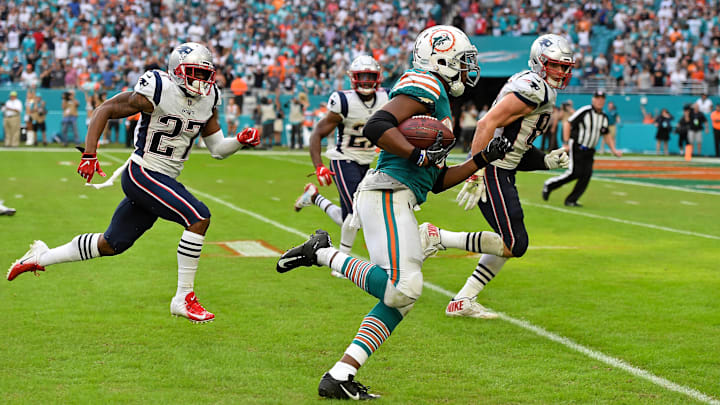 Miami Dolphins running back Kenyan Drake (32) runs the ball after a latteral play to score a touchdown to defeat the New England Patriots at Hard Rock Stadium in 2018.