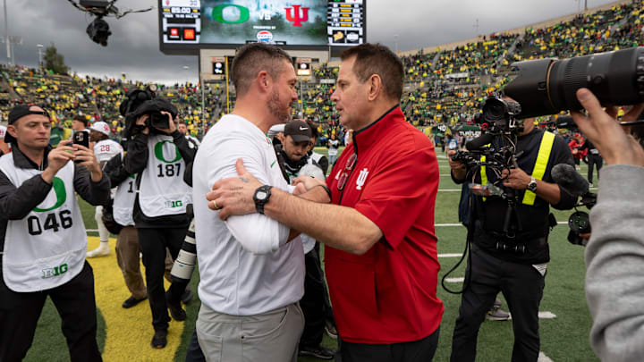 Oregon head coach Dan Lanning shakes hands with Indiana head coach Curt Cignetti.