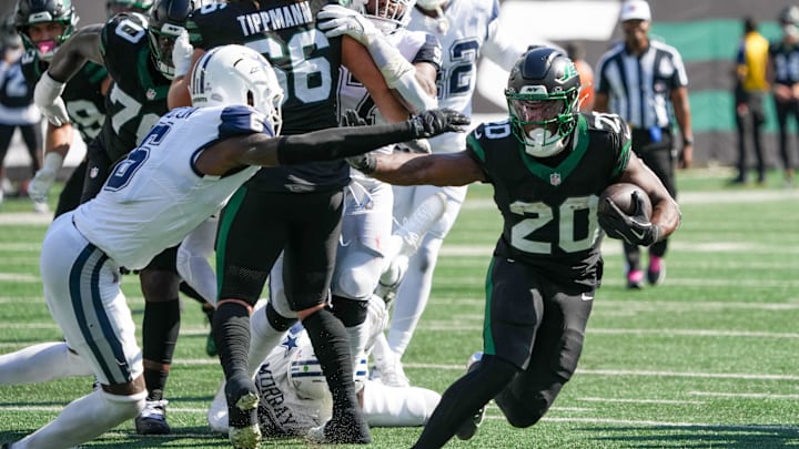 Oct 5, 2025; East Rutherford, New Jersey, USA; New York Jets running back Breece Hall (20) carries the ball as he works around Dallas Cowboys safety Donovan Wilson (6) during the first half at MetLife Stadium. Mandatory Credit: Robert Deutsch-Imagn Images