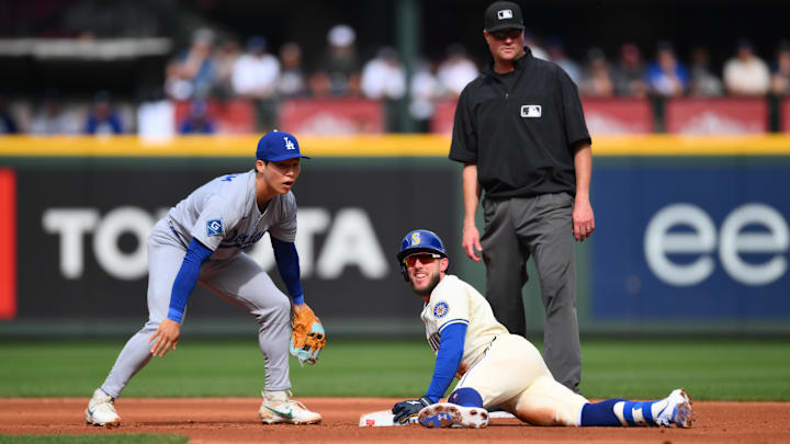 Sep 28, 2025; Seattle, Washington, USA; Seattle Mariners center fielder Miles Mastrobuoni (21) looks back after avoiding a tag by Los Angeles Dodgers second baseman Hyeseong Kim (6) during the third inning at T-Mobile Park. Mandatory Credit: Steven Bisig-Imagn Images