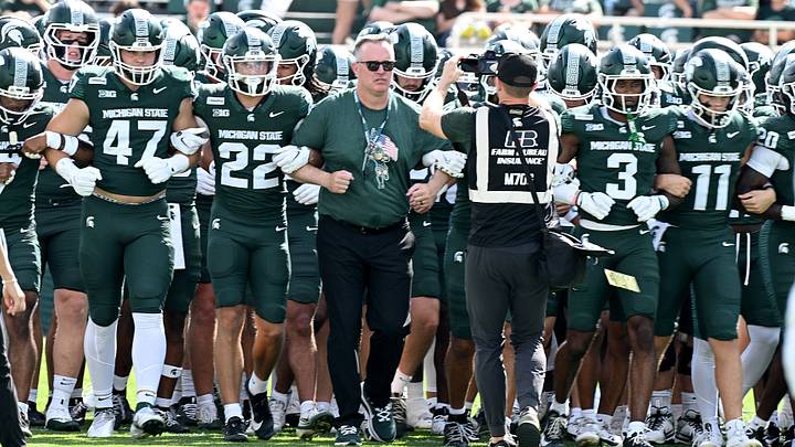 Sep 12, 2026; East Lansing, Michigan, USA;  Michigan State Spartans head coach Pat Fitzgerald links arms with his team as they march across the field before facing Eastern Michigan Eagles at Spartan Stadium.  Mandatory Credit: Dale Young-Imagn Images
