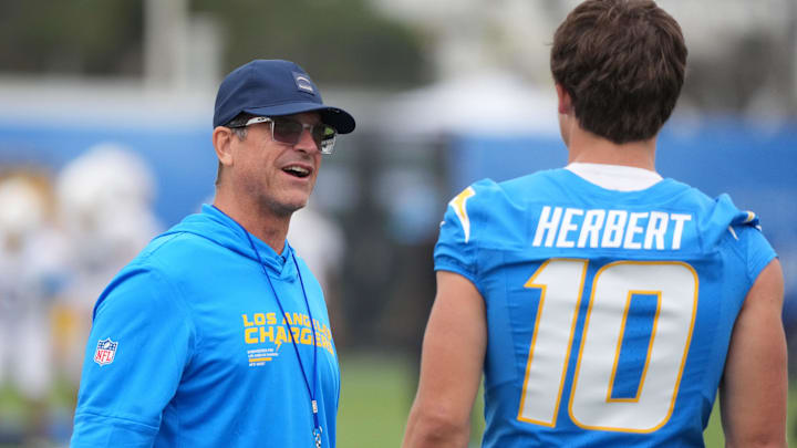 Los Angeles Chargers coach Jim Harbaugh (left) talks with quarterback Justin Herbert at training camp at The Bolt.
