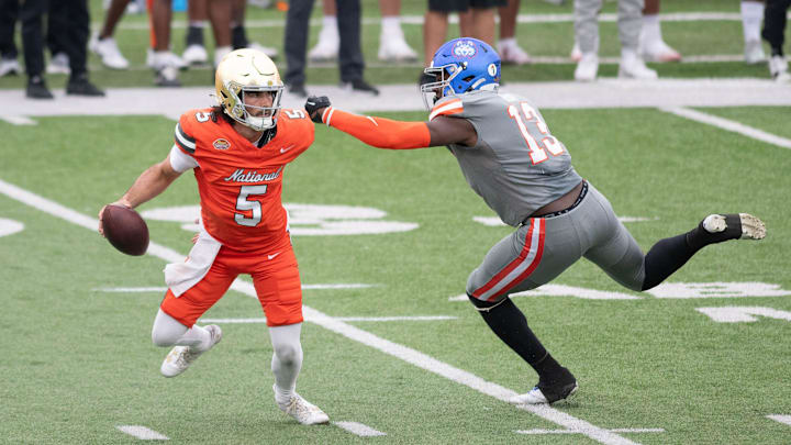 Former Notre Dame QB Sam Hartman (5) avoids the initial rush of Houston Christian LB Jalyx Hunt (13) during the Reese's Senior Bowl in Mobile, Alabama on Saturday, Feb. 3, 2024. Former Notre Dame QB Sam Hartman (5) avoids the initial rush of Houston Christian LB Jalyx Hunt (13) during the Reese's Senior Bowl in Mobile, Alabama on Saturday, Feb. 3, 2024.