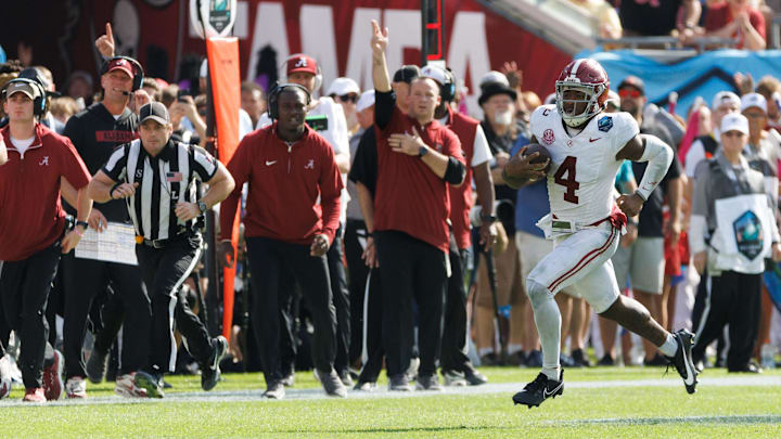 Dec 31, 2024; Tampa, FL, USA; Alabama Crimson Tide quarterback Jalen Milroe (4) runs with the ball while the sideline reacts against the Michigan Wolverines during the second half at Raymond James Stadium. Mandatory Credit: Matt Pendleton-Imagn Images