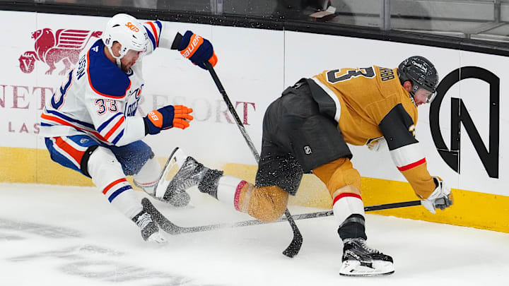 May 8, 2025; Las Vegas, Nevada, USA; Edmonton Oilers left wing Viktor Arvidsson (33) trips Vegas Golden Knights defenseman Brayden McNabb (3) during an overtime period of game two of the second round of the 2025 Stanley Cup Playoffs at T-Mobile Arena. Mandatory Credit: Stephen R. Sylvanie-Imagn Images