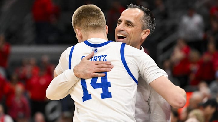 Mar 9, 2025; St. Louis, Missouri, USA;  Drake Bulldogs head coach Ben McCollum hugs guard Bennett Stirtz (14) after defeating the Bradley Braves to win the Missouri Valley Conference Tournament Championship at Enterprise Center. Mandatory Credit: Jeff Curry-Imagn Images