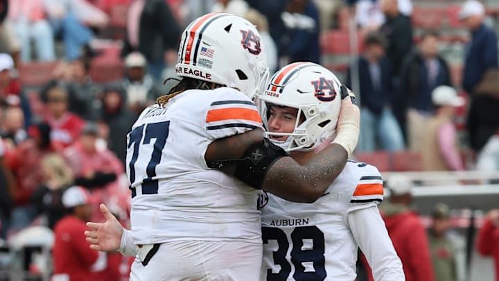 Oct 25, 2025; Fayetteville, Arkansas, USA; Auburn Tigers offensive lineman Jeremiah Wright (77) celebrates with kicker Alex McPherson (38) after a field goal late in the fourth quarter against the Arkansas Razorbacks at Donald W. Reynolds Razorback Stadium. Auburn won 33-24. Mandatory Credit: Nelson Chenault-Imagn Images