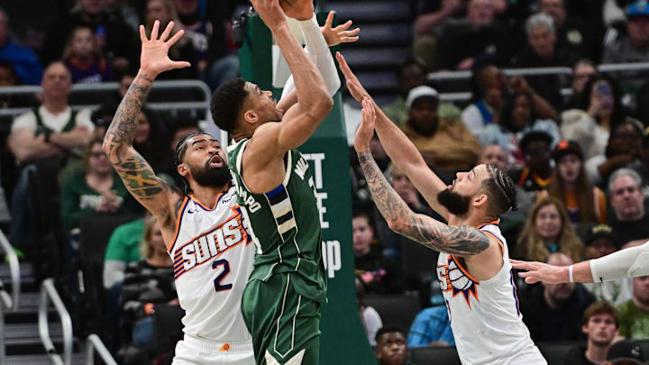 Apr 1, 2025; Milwaukee, Wisconsin, USA;  Milwaukee Bucks forward Giannis Antetokounmpo (34) takes a shot against Phoenix Suns center Nick Richards (2) and  forward Cody Martin (17) in the second quarter at Fiserv Forum. Mandatory Credit: Benny Sieu-Imagn Images