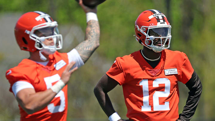 Cleveland Browns quarterback Shedeur Sanders (12) watches as quarterback Dillon Gabriel (5) throws during NFL rookie minicamp at the Cleveland Browns training facility on Friday, May 9, 2025, in Berea, Ohio.
