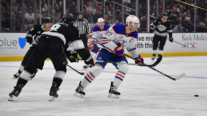 Apr 29, 2025; Los Angeles, California, USA; Edmonton Oilers center Connor McDavid (97) moves the puck against Los Angeles Kings defenseman Drew Doughty (8) during the third period in game five of the first round of the 2025 Stanley Cup Playoffs at Crypto.com Arena. Mandatory Credit: Gary A. Vasquez-Imagn Images