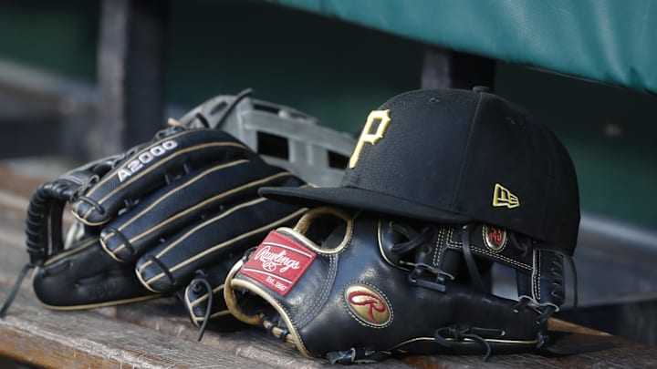 Aug 8, 2023; Pittsburgh, Pennsylvania, USA;  Pittsburgh Pirates hat and gloves in the dugout against the Atlanta Braves during the fourth inning at PNC Park. Mandatory Credit: Charles LeClaire-Imagn Images