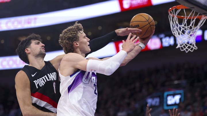 Oct 29, 2025; Salt Lake City, Utah, USA; Utah Jazz forward Lauri Markkanen (23) lays the ball up and is fouled by Portland Trail Blazers forward Deni Avdija (8) during the second half at Delta Center. Mandatory Credit: Rob Gray-Imagn Images