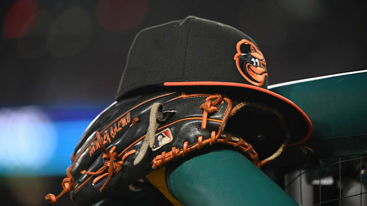 May 8, 2024; Washington, District of Columbia, USA; A Baltimore Orioles hat and glove rest on the dugout rail during a game against the Washington Nationals at Nationals Park. 