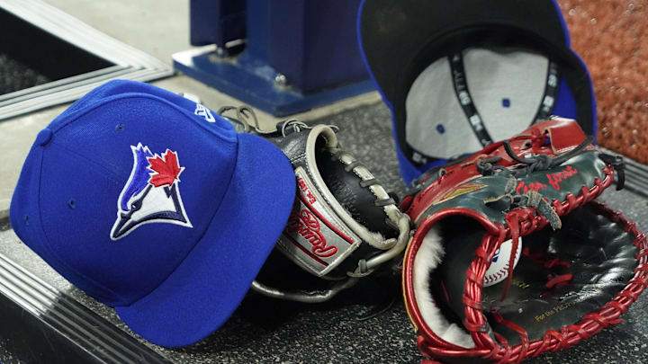 Apr 27, 2024; Toronto, Ontario, CAN; A pair of Toronto Blue Jays hats and gloves in the dugout during the first inning against the Los Angeles Dodgers at Rogers Centre. Mandatory Credit: John E. Sokolowski-Imagn Images
