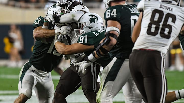 MSU DT Alex VanSumeren (97) and LB Ben VanSumeren tackle LB Zaire Barnes WMU RB La'Darius Jefferson Friday, Sept. 2, 2022, during the season opener at Spartan Stadium.

Dsc 6796