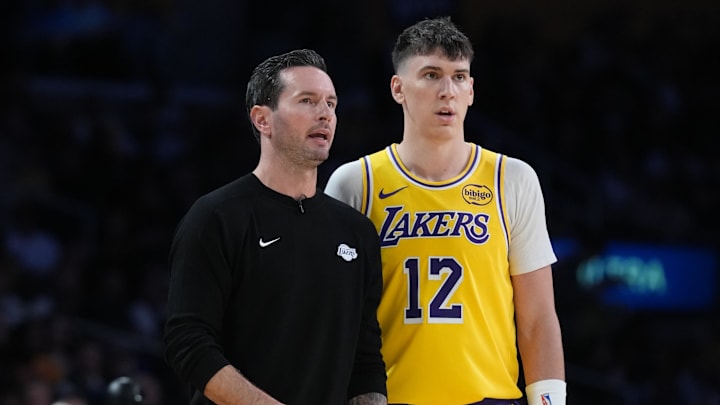Oct 24, 2025; Los Angeles, California, USA; Los Angeles Lakers head coach JJ Redick talks with forward Jake LaRavia (12) in the second half against the Minnesota Timberwolves at Crypto.com Arena. Mandatory Credit: Kirby Lee-Imagn Images