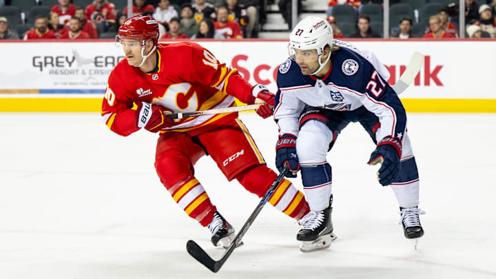 Blue Jackets winger Zach Aston-Reese alongside Flames winger Jonathan Huberdeau.