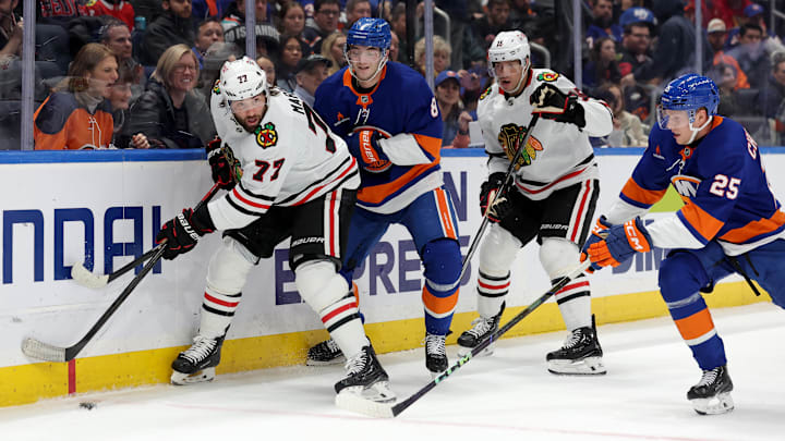 Dec 12, 2024; Elmont, New York, USA; Chicago Blackhawks left wing Patrick Maroon (77) and center Craig Smith (15) fights for the puck against New York Islanders defensemen Noah Dobson (8) and Dennis Cholowski (25) during the first period at UBS Arena. Mandatory Credit: Brad Penner-Imagn Images