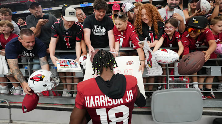 Arizona Cardinals receiver Marvin Harrison Jr. (18) signs autographs for fans during training camp at State Farm Stadium in Glendale on July 28, 2024.