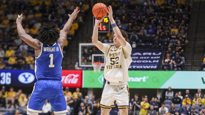 Feb 28, 2026; Morgantown, West Virginia, USA; West Virginia Mountaineers guard Treysen Eaglestaff (52) shoots a three pointer over BYU Cougars guard Robert Wright III (1) during the second half at Hope Coliseum. Mandatory Credit: Ben Queen-Imagn Images