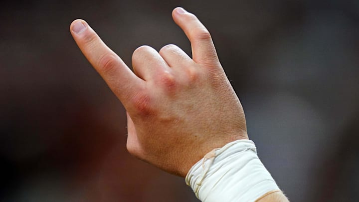 Texas Longhorns fan shows the hook 'em horns sign during the fourth quarter of the game between the Washington Huskies Texas Longhorns fan shows the hook 'em horns sign during the fourth quarter of the game between the Washington Huskies