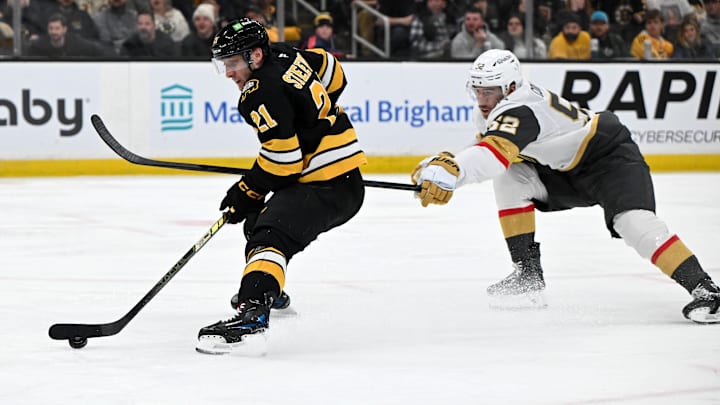 Jan 22, 2026; Boston, Massachusetts, USA; Vegas Golden Knights defenseman Dylan Coghlan (52) defends Boston Bruins center Alex Steeves (21) during the third period at the TD Garden. Mandatory Credit: Brian Fluharty-Imagn Images
