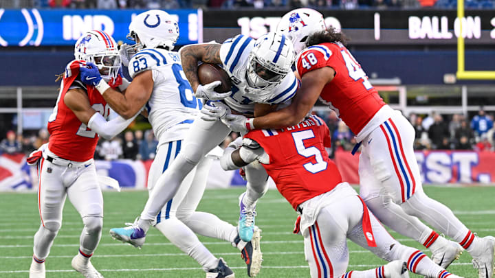 Dec 1, 2024; Foxborough, Massachusetts, USA; Indianapolis Colts wide receiver Michael Pittman Jr. (11) is tackled by New England Patriots safety Jabrill Peppers (5) and linebacker Jahlani Tavai (48) during the second half at Gillette Stadium. Mandatory Credit: Eric Canha-Imagn Images