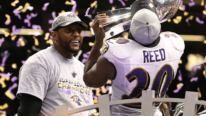 Baltimore Ravens safety Ed Reed kisses the Vince Lombardi Trophy as linebacker Ray Lewis smiles.