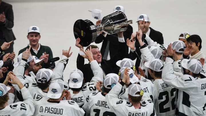Michigan State hockey coach Adam Nightingale hoists the Big Ten tournament championship trophy after Michigan State hockey coach Adam Nightingale hoists the Big Ten tournament championship trophy after