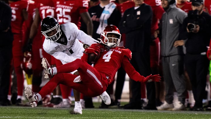 Cincinnati Bearcats cornerback Jordan Young (1) tackled Houston Cougars wide receiver Samuel Brown (4) in the fourth quarter of the NCAA football game between the Cincinnati Bearcats and the Houston Cougars TDECU Stadium in Houston, Texas, on Saturday, Nov. 11, 2023.