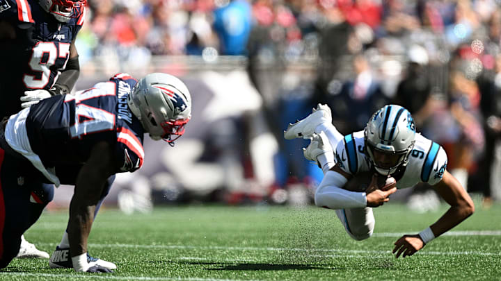 Sep 28, 2025; Foxborough, Massachusetts, USA; Carolina Panthers quarterback Bryce Young (9) slips and falls under preasure from New England Patriots defensive end Milton Williams (97) and linebacker K'Lavon Chaisson (44) during the first half at Gillette Stadium. 