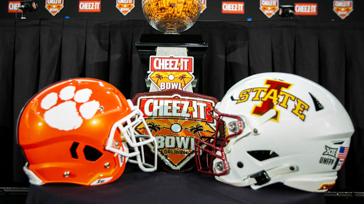 A bowl full of Cheez-It crackers are seen in the trophy on a table with football helmets for Clemson