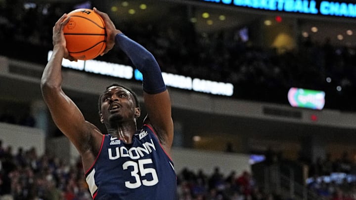 Mar 23, 2025; Raleigh, NC, USA; Connecticut Huskies center Samson Johnson (35) dunks the ball during the first half as Florida Gators guard Alijah Martin (15) defends in the second round of the NCAA Tournament at Lenovo Center. Mandatory Credit: Bob Donnan-Imagn Images