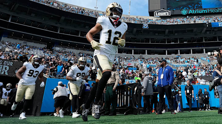 Nov 3, 2024; Charlotte, North Carolina, USA; New Orleans Saints wide receiver Chris Olave (12) runs on to the field before the game at Bank of America Stadium. Mandatory Credit: Bob Donnan-Imagn Images