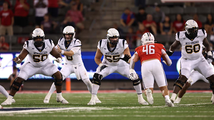The WVU football offensive line protects Mountaineers' quarterback Nicco Marchiol against Arizona during the 2024 season.