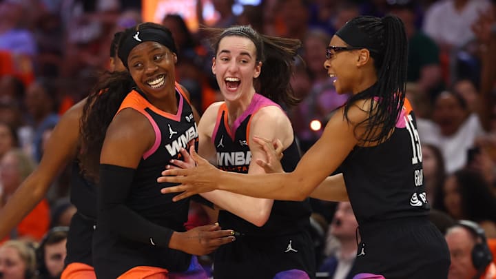 Jul 20, 2024; Phoenix, AZ, USA; Team WNBA player Arike Ogunbowale celebrates with Caitlin Clark and Allisha Gray after making a three point shot during the second half against the USA Women's National Team at Footprint Center. Mandatory Credit: Mark J. Rebilas-Imagn Images
