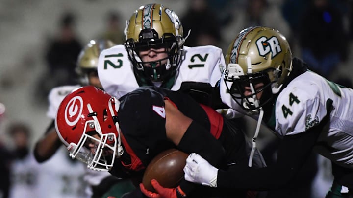 Greenville's Alijah Jones (4) is tackled by Catawba Ridge's Eric Johnson (44) and Evan Hamilton (12) during a game against Catawba Ridge that ended in a 42-27 win for Greenville at Sirrine Stadium on Friday, Nov. 18, 2022.