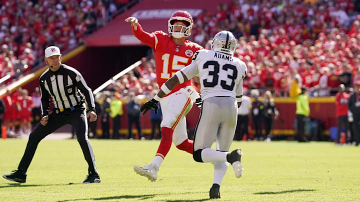 Oct 19, 2025; Kansas City, Missouri, USA; Kansas City Chiefs quarterback Patrick Mahomes (15) passes the ball under pressure from Las Vegas Raiders linebacker Jamal Adams (33) during the second quarter of the game at GEHA Field at Arrowhead Stadium. Mandatory Credit: Denny Medley-Imagn Images