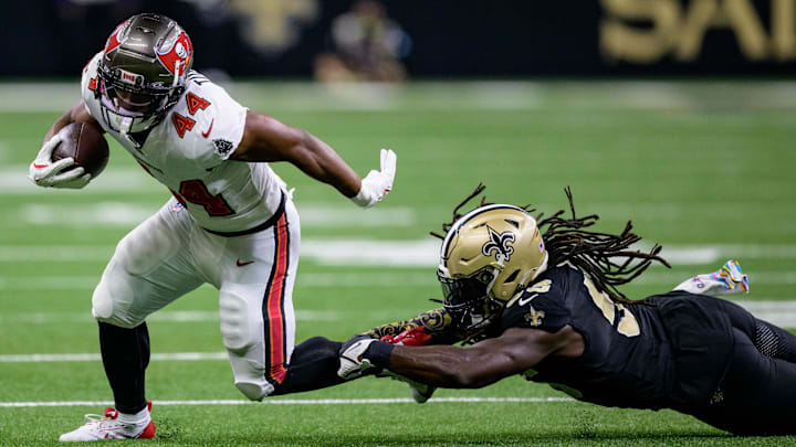 Oct 13, 2024; New Orleans, Louisiana, USA; Tampa Bay Buccaneers running back Sean Tucker (44) breaks a tackle attempt by New Orleans Saints linebacker Demario Davis (56) during the first half at Caesars Superdome. Mandatory Credit: Matthew Hinton-Imagn Images
