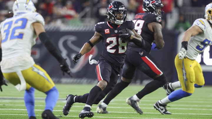 Jan 11, 2025; Houston, Texas, USA; Houston Texans running back Joe Mixon (28) runs with the ball during the game against the Los Angeles Chargers in an AFC wild card game at NRG Stadium. Mandatory Credit: Troy Taormina-Imagn Images